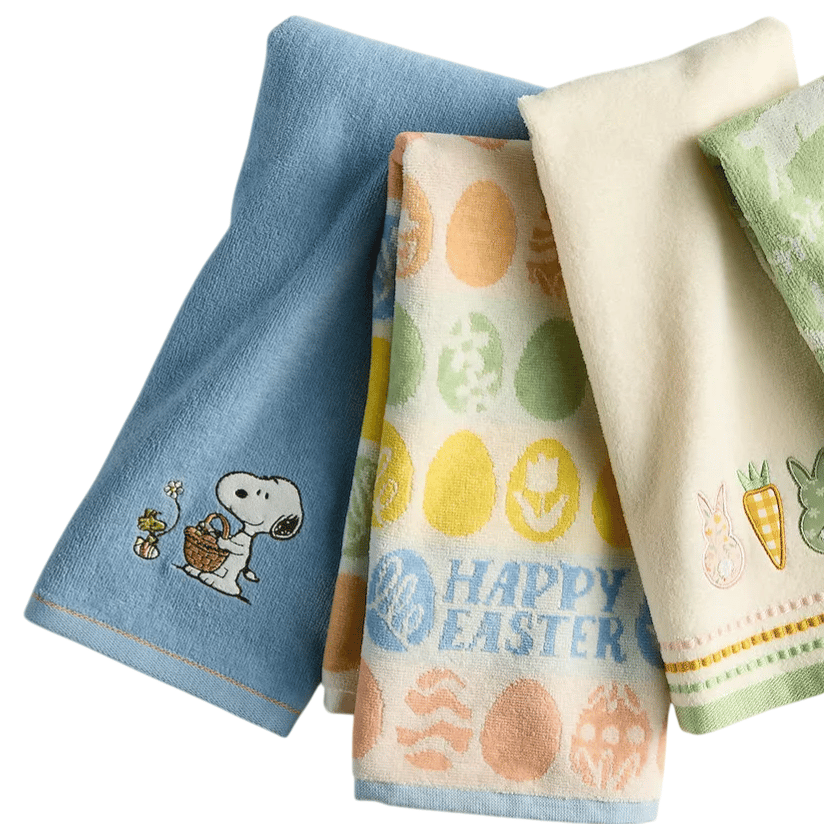 Four hand towels with Easter-themed designs, including eggs and bunnies, alongside a green bar of soap. One towel features a dog character holding a basket.