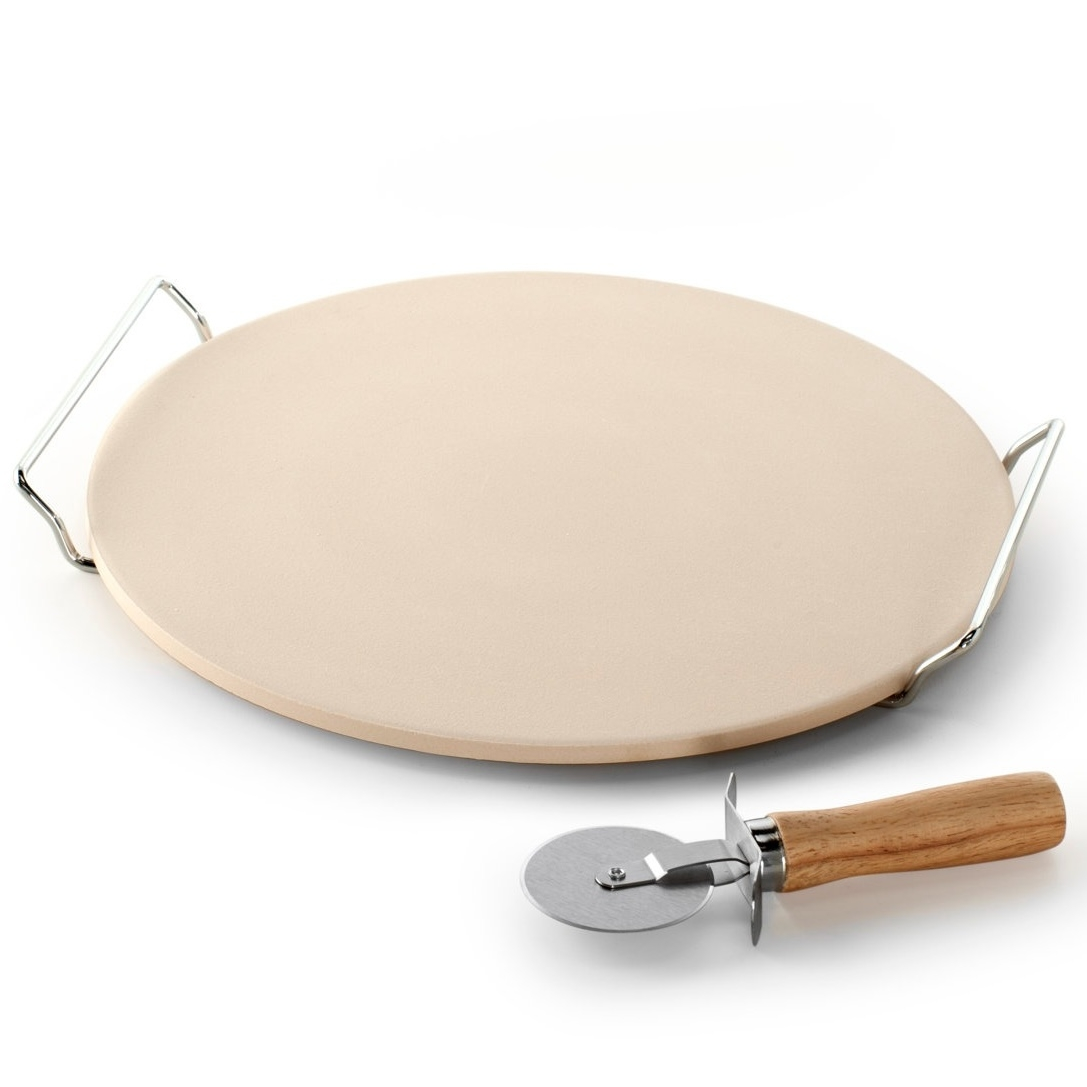 A round pizza stone with metal handles and a wooden-handled pizza cutter.