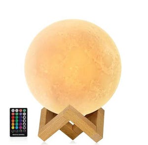A moon lamp with a wooden stand and a remote control for adjusting colors and brightness.