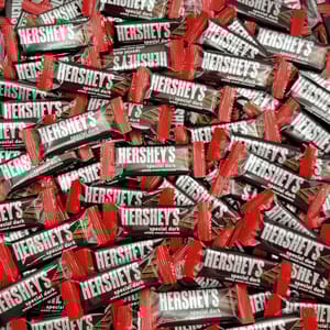 Hershey's Special Dark mildly sweet chocolate bars with red wrappers are displayed in a large pile.