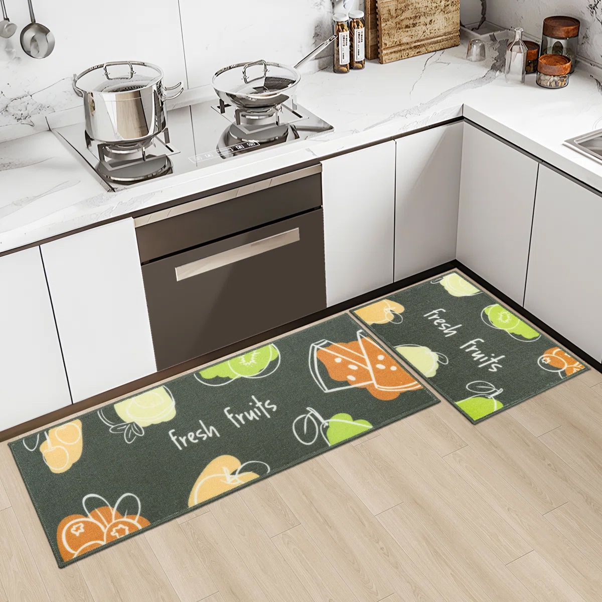 Two kitchen mats with a \“fresh fruits\“ theme featuring colorful fruit illustrations placed in an L-shape on a light wood floor near a stove.