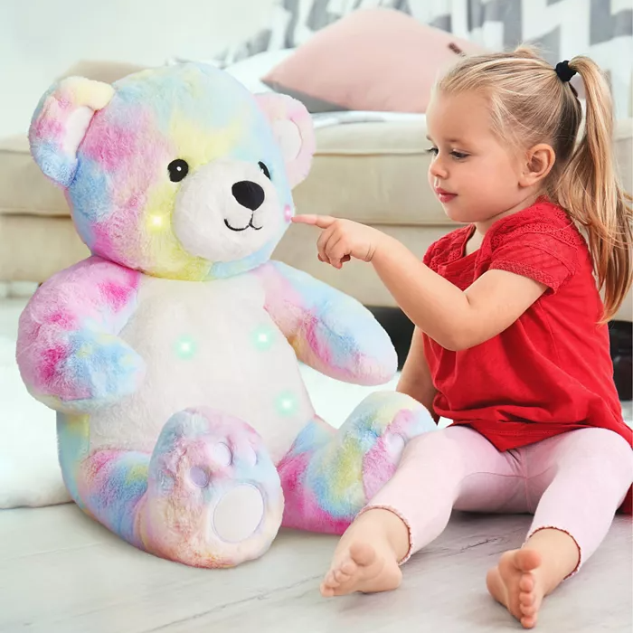 A 22\“ LED plush teddy bear with a soft, multicolored pastel design featuring illuminated points on its body, sitting next to a young child. The bear has a friendly face and is designed for play and companionship.