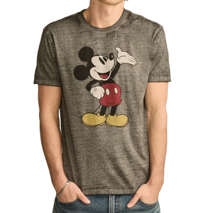 A gray T-shirt featuring a vintage-style illustration of Mickey Mouse, with the character in red shorts and yellow shoes. The person wearing it pairs it with blue jeans and a bracelet.
