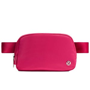 A pink Lululemon belt bag with a zippered main compartment and the brand's logo on the front.