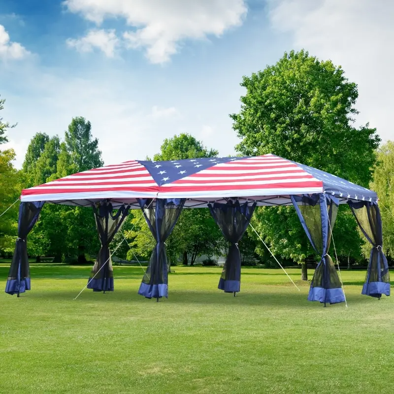 10' x 20' party tent with an American flag design canopy, featuring dark mesh curtains and anchoring ropes, set on a grassy lawn surrounded by trees.