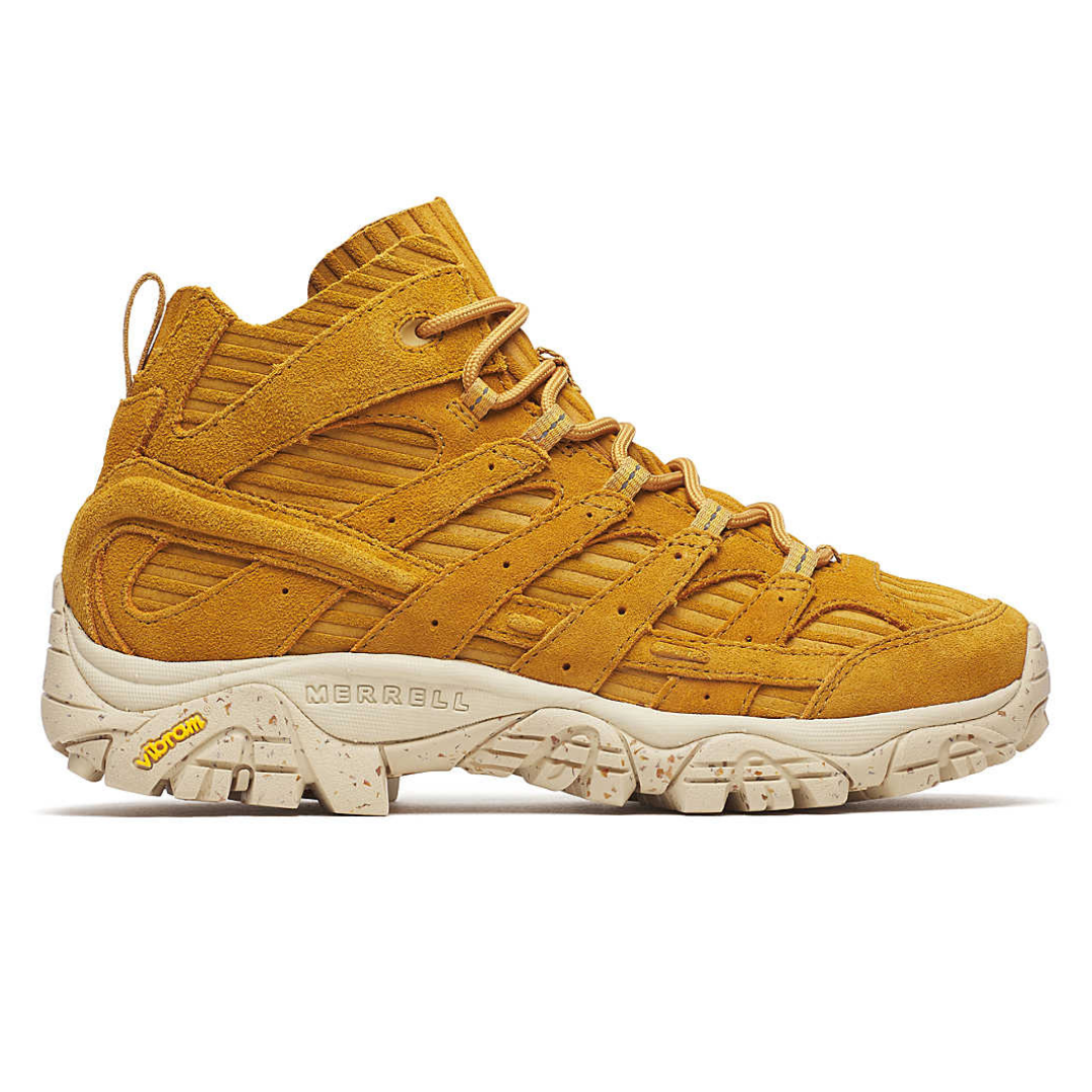A mustard-yellow mid-top sneaker by Merrell featuring a rugged design, suede material, and a Vibram sole for traction and durability.