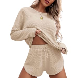 Beige waffle-knit pajamas set featuring a long-sleeve top and matching shorts with a drawstring waist, textured in a cozy, soft fabric.