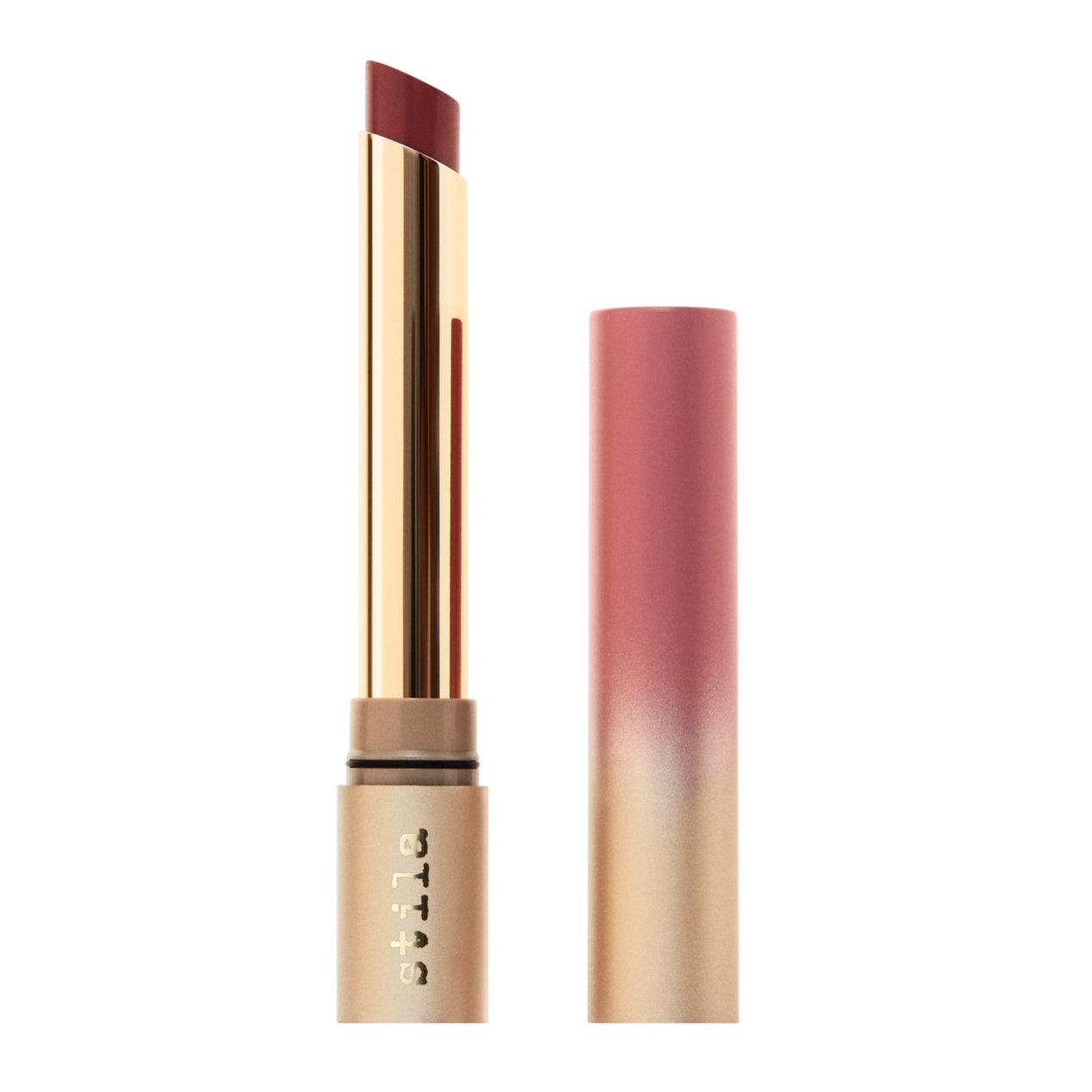 A lipstick with gold and pink ombre packaging, featuring a slim, angled bullet in a deep red shade, with \“stila\“ branding on the tube.
