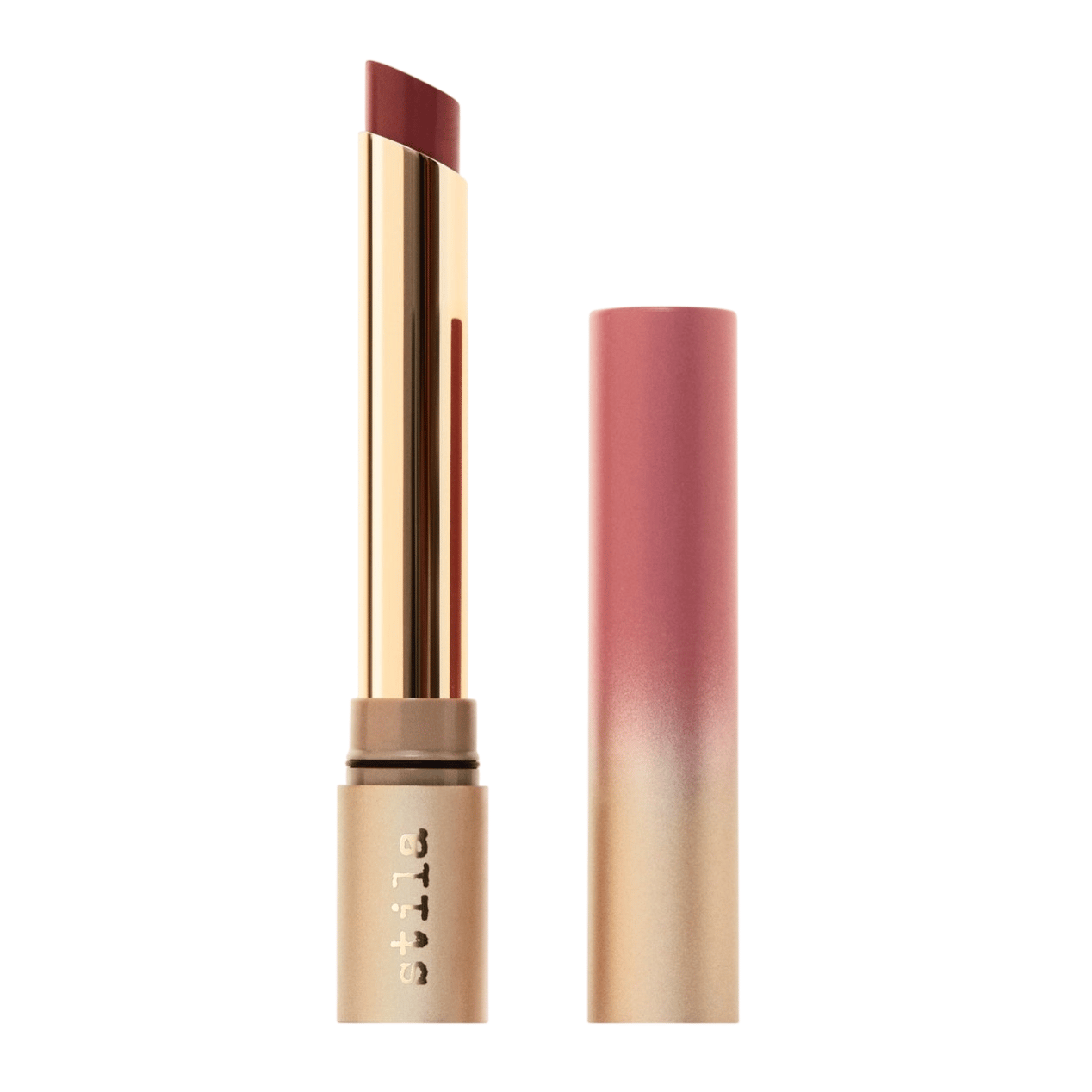 A lipstick with gold and pink ombre packaging, featuring a slim, angled bullet in a deep red shade, with \“stila\“ branding on the tube.