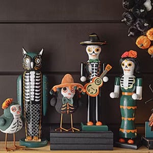 Decorative figurines inspired by the Day of the Dead, featuring stylized representations of an owl, musicians, and a dancer.