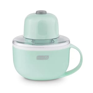A mint green Dash electric citrus juicer with a clear top, featuring a handle for easy pouring.