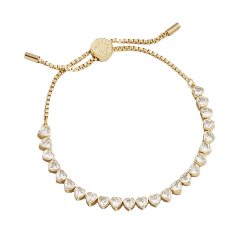 A gold-tone adjustable bracelet with heart-shaped clear stones and a sliding clasp for closure.