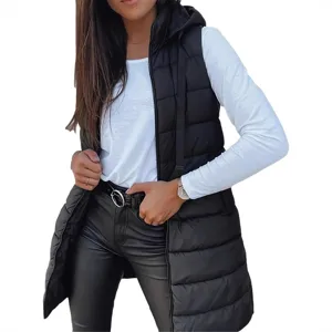 A woman is wearing a black puffer vest over a white long-sleeve shirt, black leather pants, and a belt. She has a watch on her left wrist.