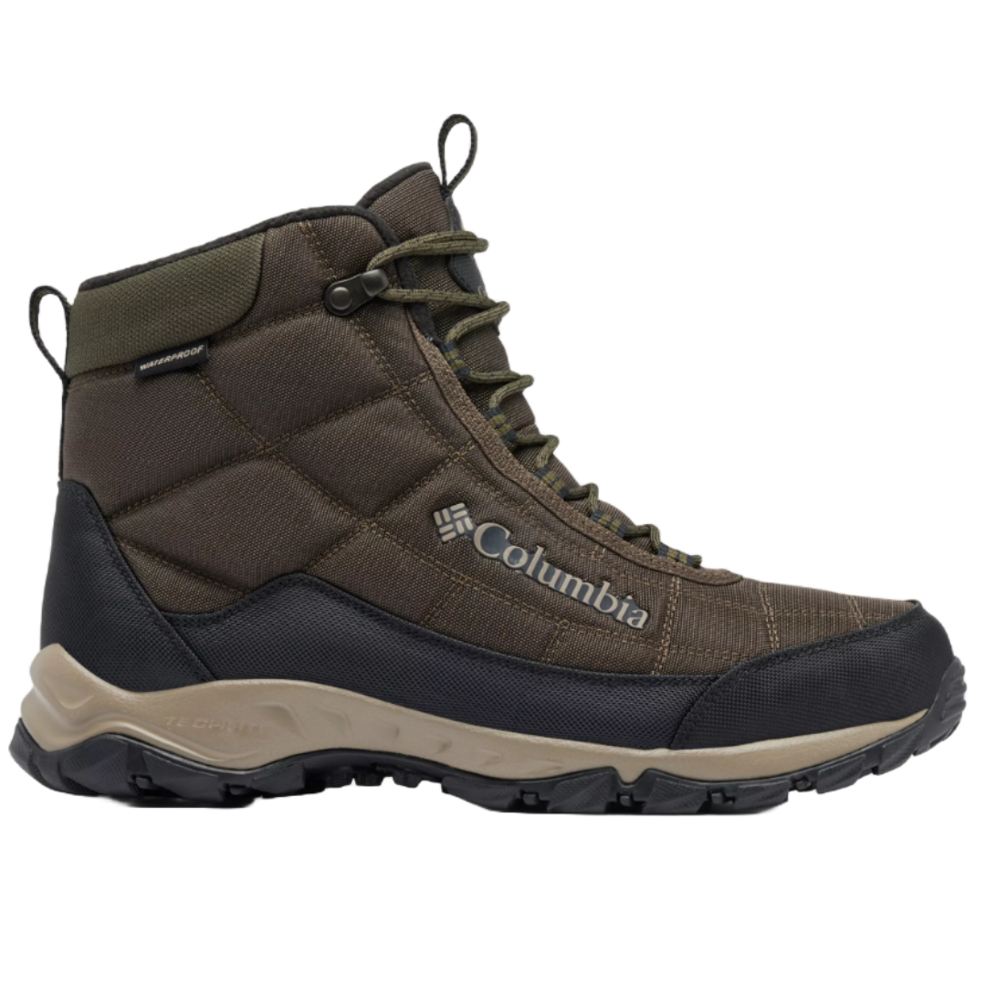 Columbia Men's Firecamp Boots are mid-height, waterproof boots featuring a brown quilted upper with reinforced toe and heel, green eyelets, and a durable, textured sole for traction. The Columbia logo is visible on the side.