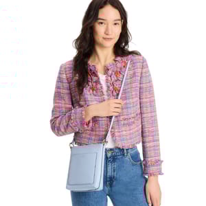 The Kate Spade Ava Swingpack is a compact crossbody bag in light blue with a front slip pocket, adjustable strap, and gold-tone hardware, ideal for carrying essentials.