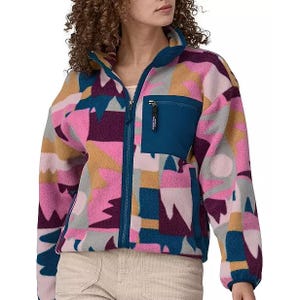 A person wearing a multicolored fleece jacket with a zippered front and chest pocket.