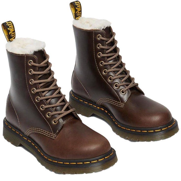 Brown Dr. Martens Serena Boots with faux fur lining, featuring 8-eye lace-up design, rugged rubber outsole, yellow stitching, and signature heel loop for easy pull-on.