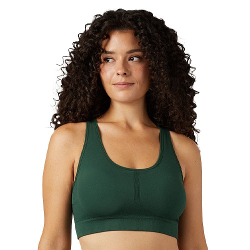 A woman models a dark green sports bra with a racerback design.