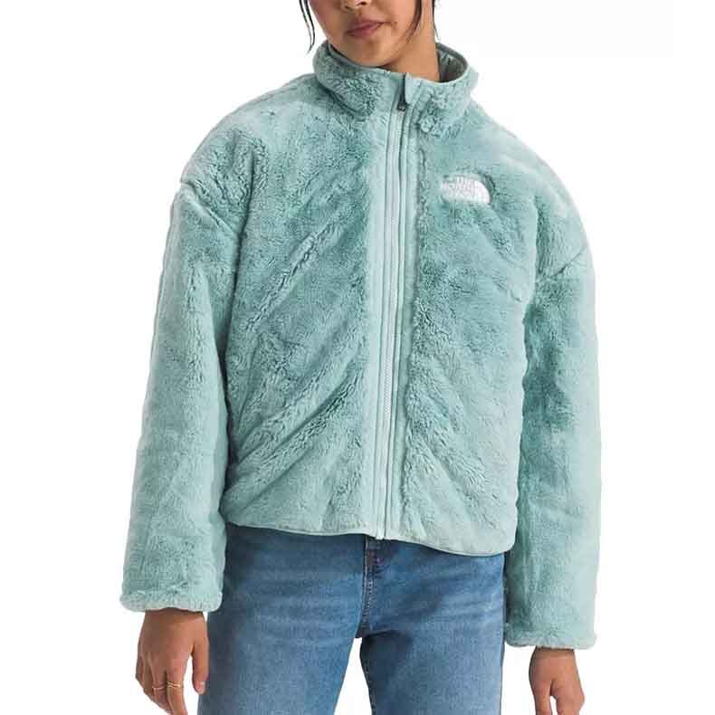 Light blue, plush, reversible full-zip jacket with a stand collar and the logo on the chest, paired with blue jeans.