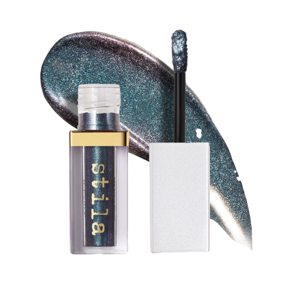 Stila liquid eyeshadow with a shimmery, iridescent blue and silver finish, shown next to its applicator wand and a swatch.