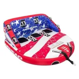 Inflatable towable tube with a patriotic red, white, and blue design, featuring stars and stripes, brand name \“Airhead\“ visible, designed for multiple riders with grab handles and seating areas.