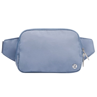 A light blue belt bag with a small Lululemon logo, featuring two zippers and an adjustable strap.