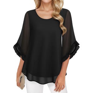 Black, flowy top with sheer ruffle sleeves and a round neckline, paired with white pants.