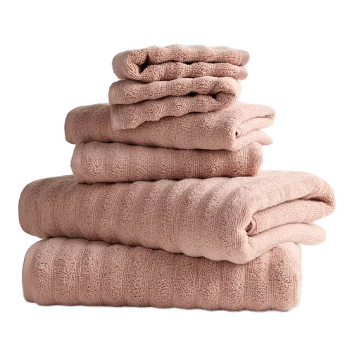 A stack of light brown towels in varying sizes neatly folded on top of each other.