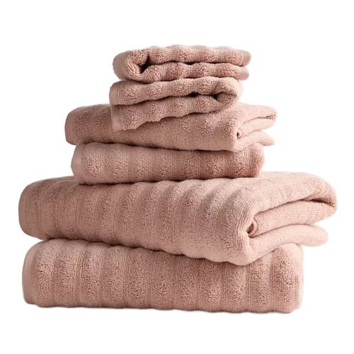 A stack of light brown towels in varying sizes neatly folded on top of each other.