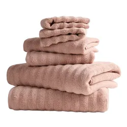 A stack of light brown towels in varying sizes neatly folded on top of each other.