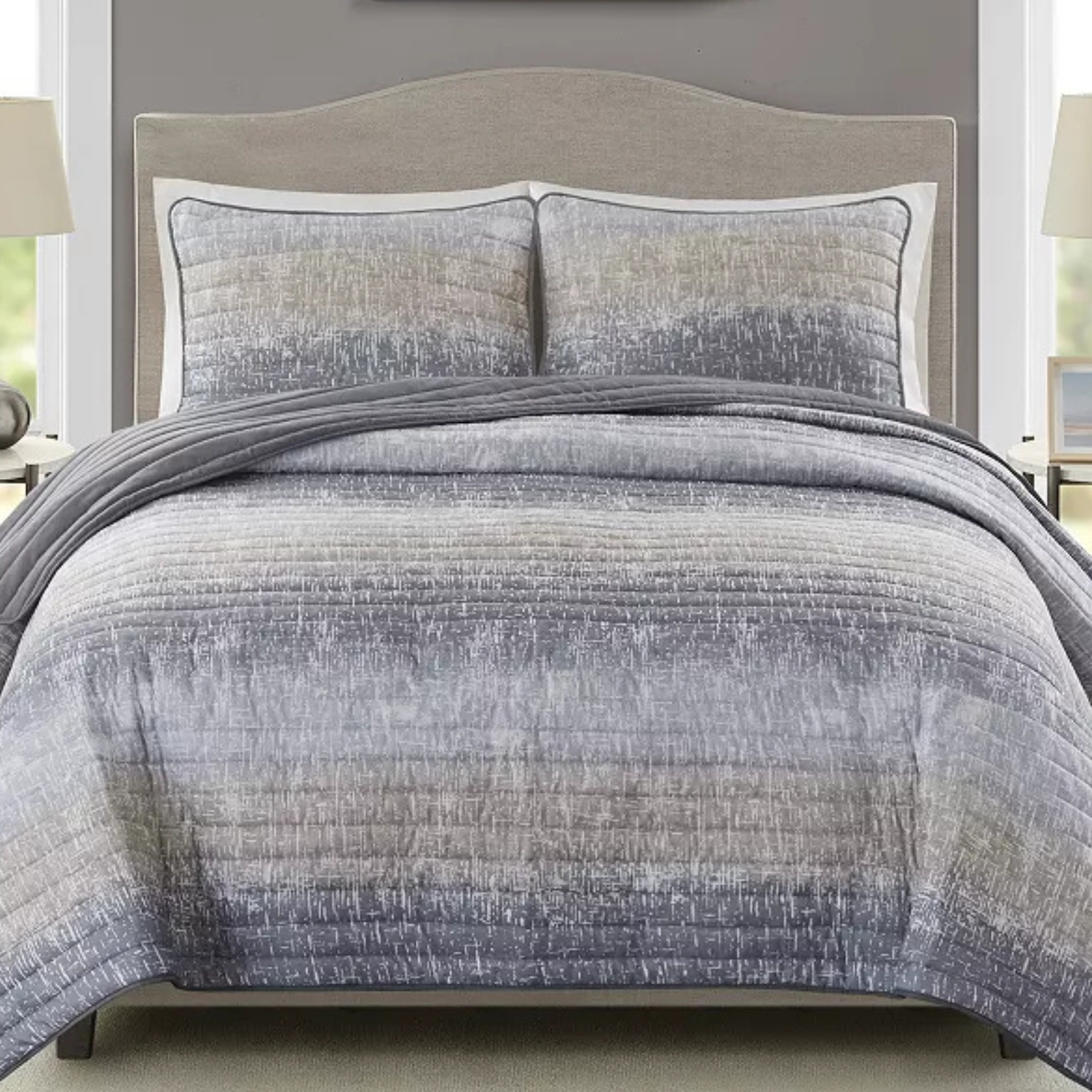 The 3pc Madison Park Queen Quilt Set includes a quilt and two shams in a gradient pattern with gray tones and subtle texture. It features a contemporary style with stitched details for a modern bedroom look.