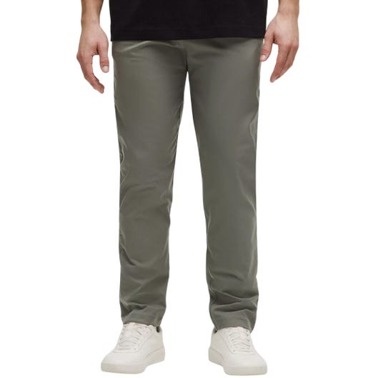 A person is wearing straight-leg, olive-green pants paired with white sneakers and a black top.