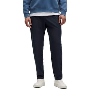 A person is wearing a blue sweatshirt, dark navy casual pants, and white sneakers.