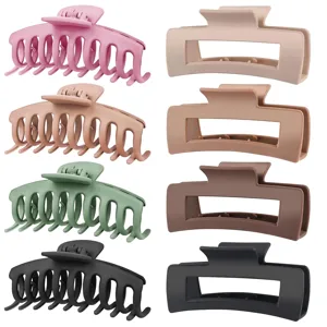 A set of four pastel and neutral-colored hair claw clips in two different shapes; curved with teeth and rectangular. Colors include pink, beige, green, and black.
