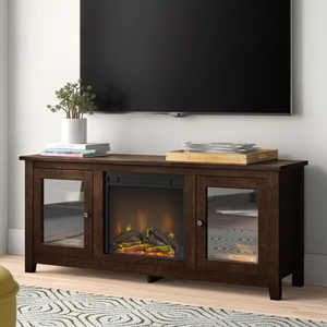 Wooden TV stand with a central electric fireplace and glass-paneled cabinets on each side. The top surface is decorated with books and a potted plant, positioned underneath a wall-mounted TV.