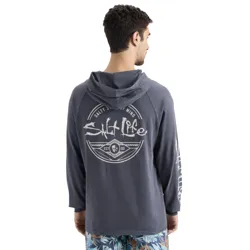 A man wearing a hooded long-sleeve shirt with \“Salt Life\“ printed on the back and sleeve, paired with tropical-patterned shorts.