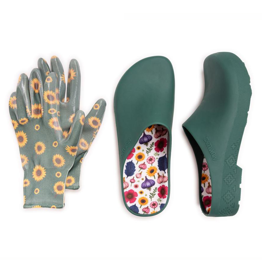 A pair of green gardening clogs with a floral-patterned insole is displayed alongside sunflower-patterned gardening gloves.