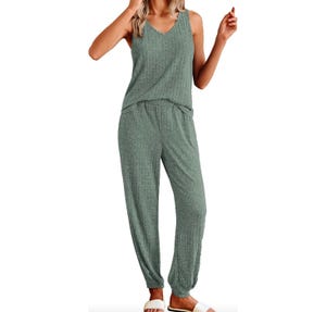 A woman is wearing a green speckled pajama set with a sleeveless top and matching pants with an elastic waistband.