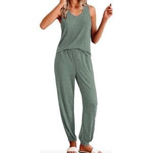 A woman is wearing a green speckled pajama set with a sleeveless top and matching pants with an elastic waistband.