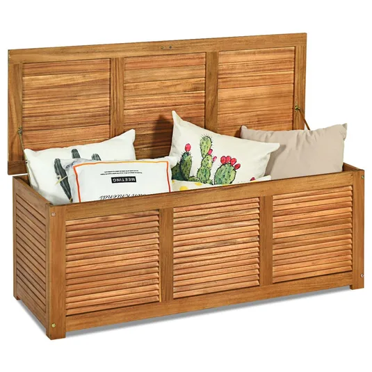 Wooden storage bench with a slatted design, filled with decorative pillows featuring cactus prints and text.