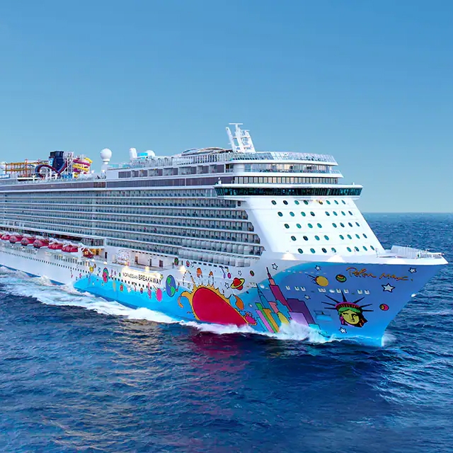 A large cruise ship with a colorful hull sailing on the ocean.