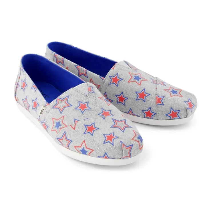 Grey TOMS Cloudbound Alpargata shoes, featuring a pattern of red and blue outlined stars, have a blue inner lining and white soles.