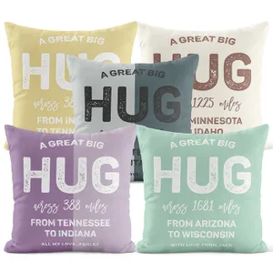 Five decorative pillows feature messages of sending a hug across various distances, with personalized notes and different state pairings.