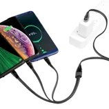 Two smartphones are being charged simultaneously using a multi-port USB cable connected to a power strip. Each device is displayed with a charging screen, showing a battery percentage.