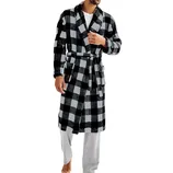 A man wears a black and gray checkered bathrobe with a belt, over a gray long-sleeve shirt and gray pants, standing barefoot against a plain background.