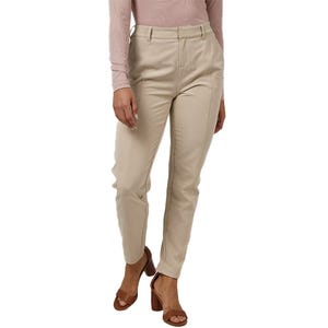 A person is wearing beige tailored pants paired with a light long-sleeve top and brown heeled sandals.
