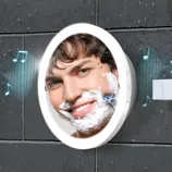 A waterproof shower mirror with integrated Bluetooth speakers, shown mounted on a tiled bathroom wall, with musical notes indicating sound playing.