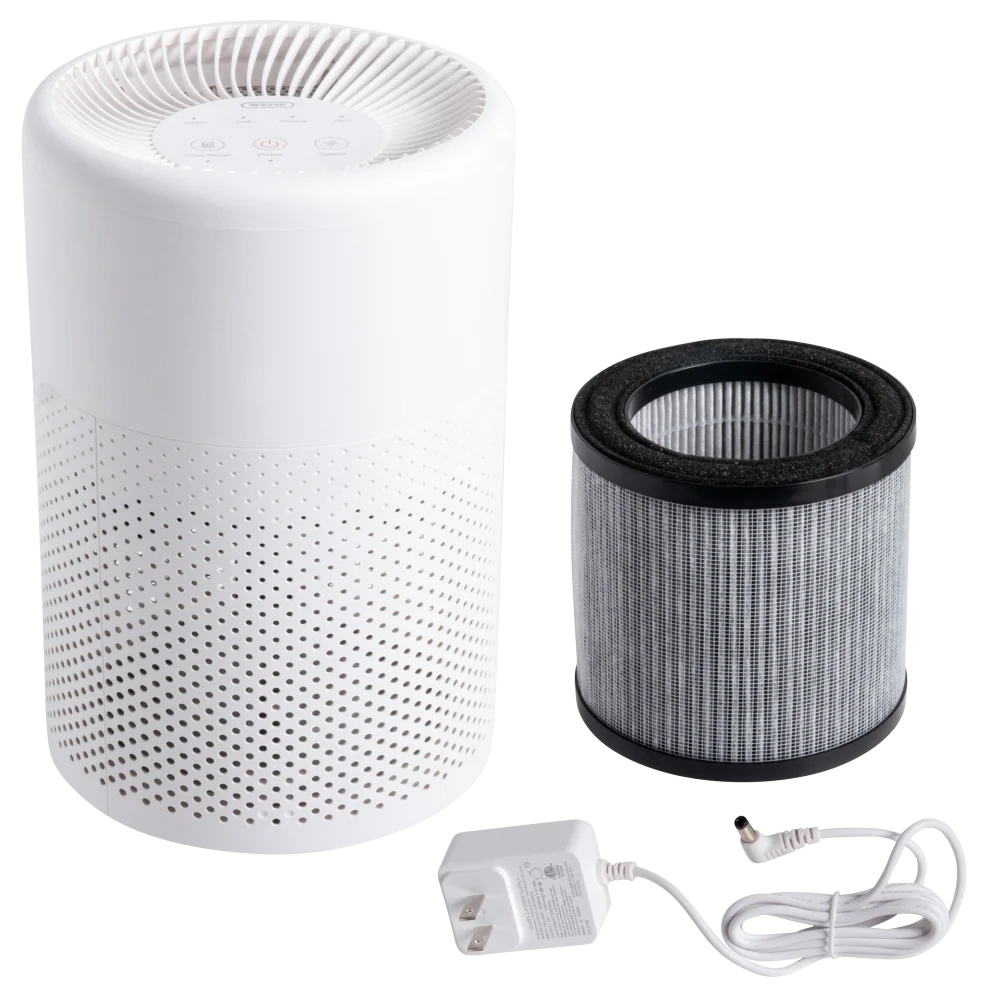 White cylindrical tabletop air purifier with perforated design, shown with a cylindrical replaceable filter and a white power adapter.