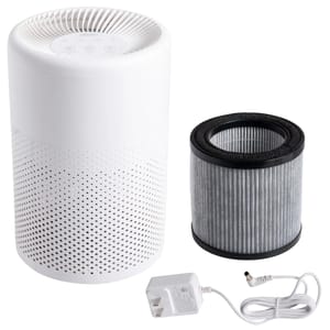 White cylindrical tabletop air purifier with perforated design, shown with a cylindrical replaceable filter and a white power adapter.