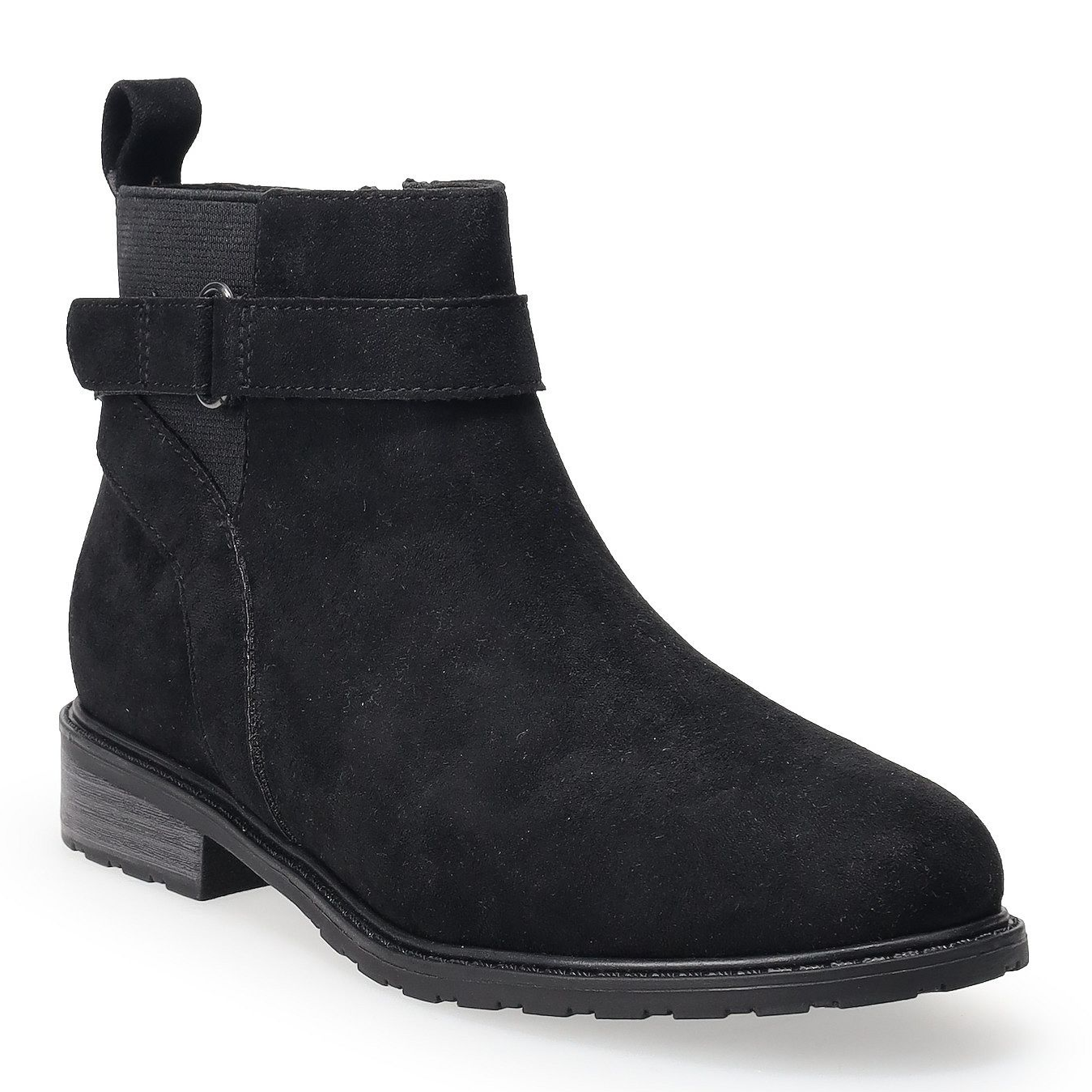 A black suede ankle boot with a strap detail, featuring a low block heel and a pull tab at the back.